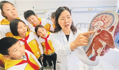 3月20日，河北省秦皇岛市海港医院睡眠障碍科医生为海港区外语实验学校学生讲解脑科学与睡眠知识。 　　曹建雄摄（人民图片）